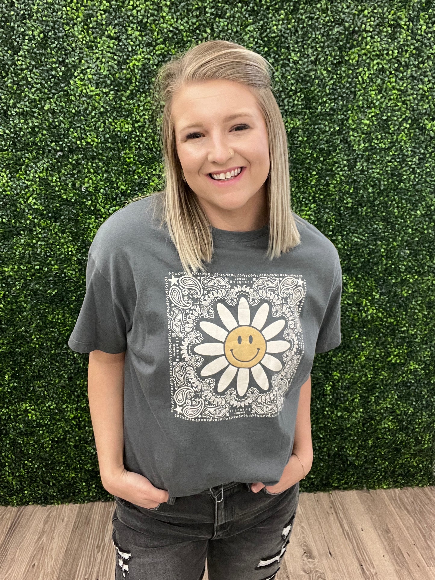 This is a charcoal gray cropped tee with a western floral print. It also features a daisy with a smiley face in the middle. It would pair perfectly with denim and a fun hat! Add some turquoise jewelry to complete the look. 