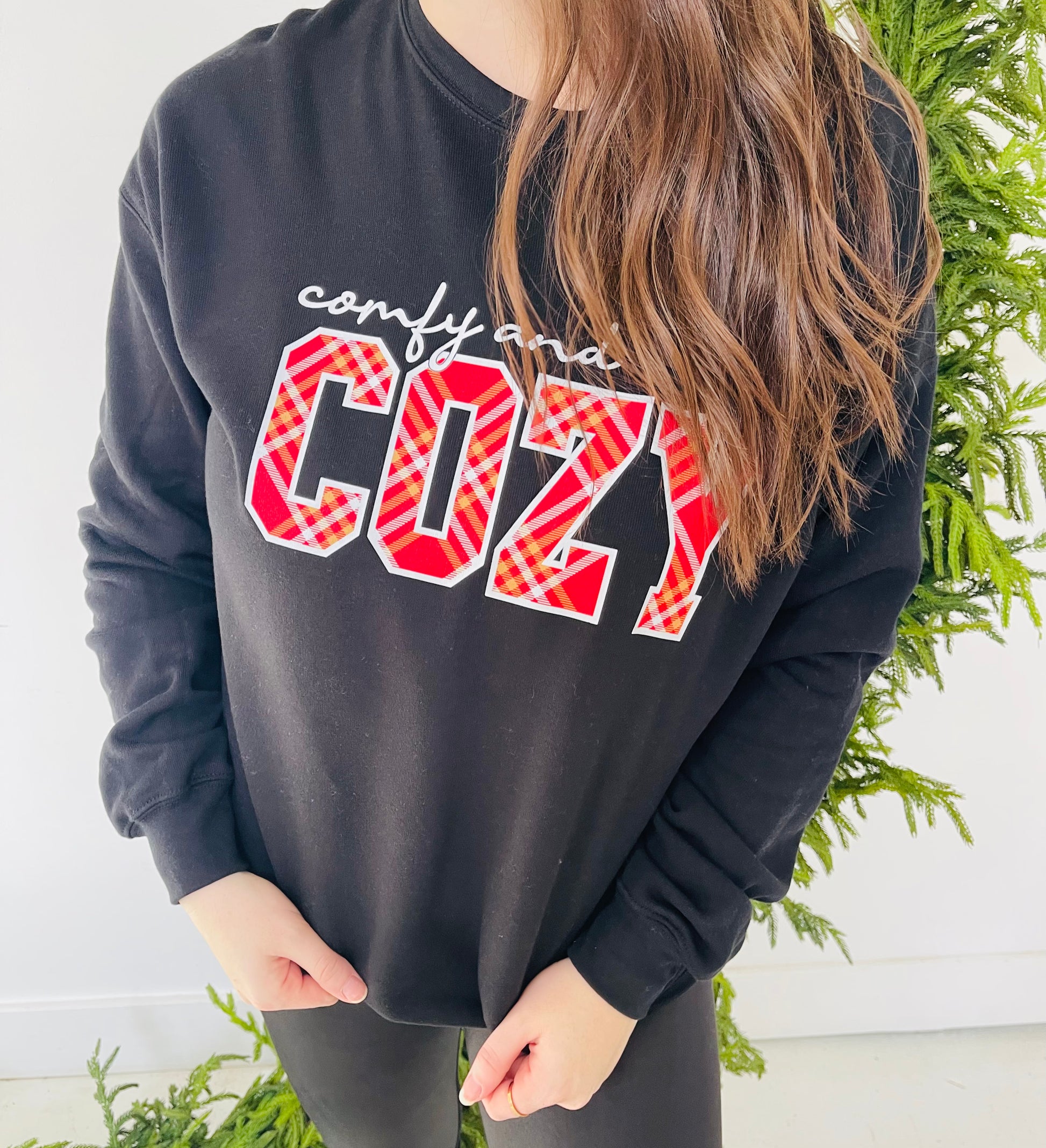 Cozy, comfy, need! This sweatshirt is a black crew neckline with a white, plaid, and gold graphic. This is great to pair with leggings for a Holiday party or to throw on at night during the Holidays!