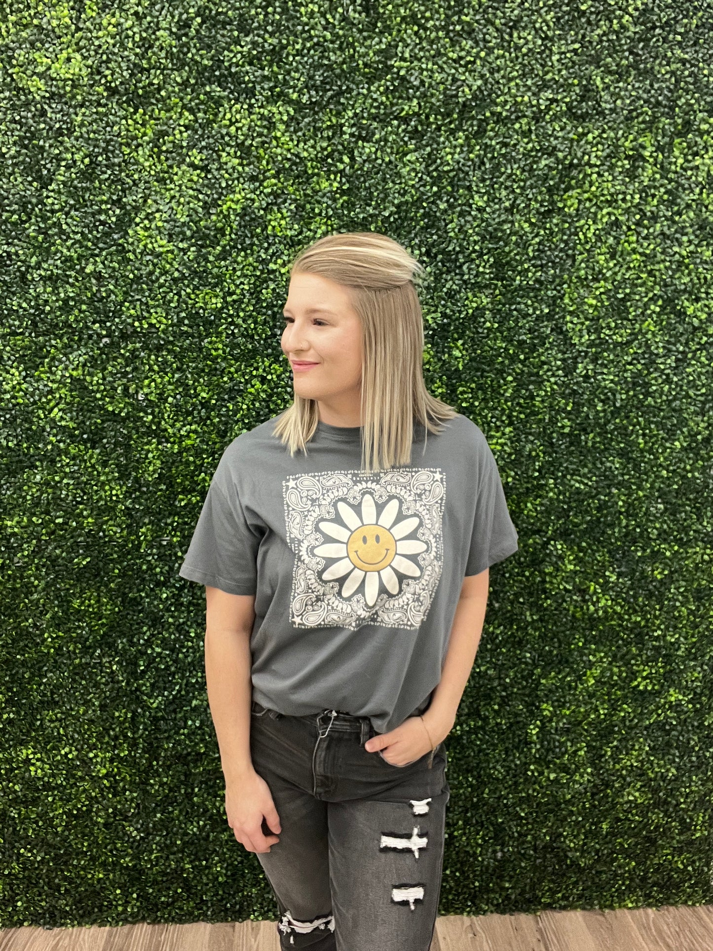 This is a charcoal gray cropped tee with a western floral print. It also features a daisy with a smiley face in the middle. It would pair perfectly with denim and a fun hat! Add some turquoise jewelry to complete the look. 