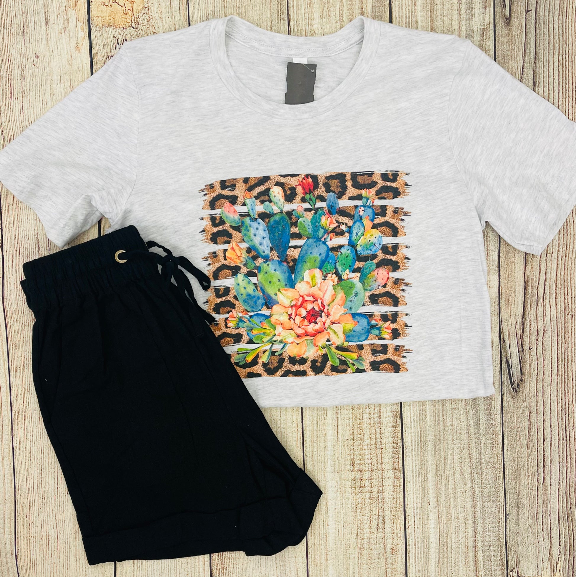 This tshirt is a heather light gray color with a crew neckline. It is a regular unisex fit with a graphic featuring a leopard background and a colorful array of blue, orange, and red cactus. 